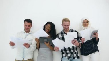 Duvarın yanında duran ve grafiklerle resmedilen neşeli, farklı renkte ofis çalışanlarının yakın görüntüsü