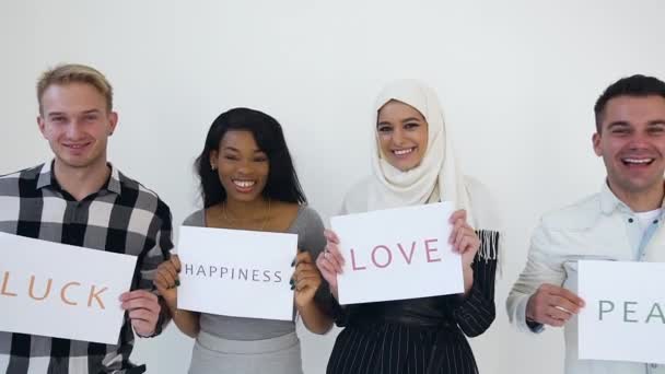 Memnuniyetle gülümseyen modern çoklu etnik gençlik herkesi geleceği inşa etmeye çağırıyor sevgi, barış, şans ve mutlulukla. — Stok video