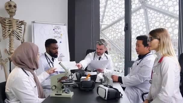 The team of adult experienced multiracial male and female doctors in meeting room during symposium about decision global medicine problems — 비디오