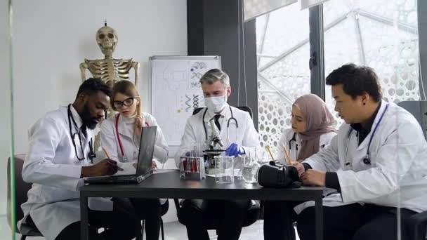 Attractive portrait of experienced head doctor during his lecture with multiracial good-looking doctors-interns — 비디오