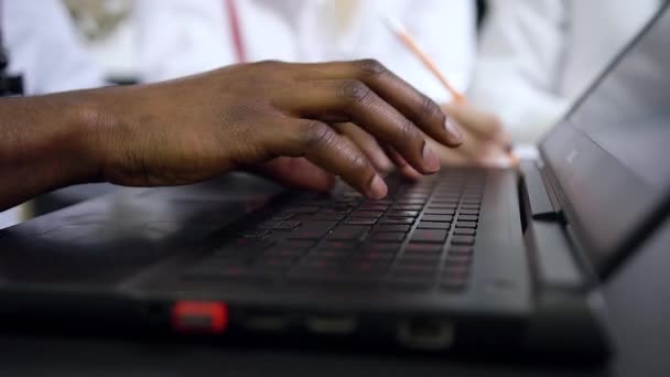 Αργή κίνηση των καλοδιατηρημένων σκουρόχρωμων αρσενικών χεριών που πληκτρολογούν στο πληκτρολόγιο του υπολογιστή — Αρχείο Βίντεο