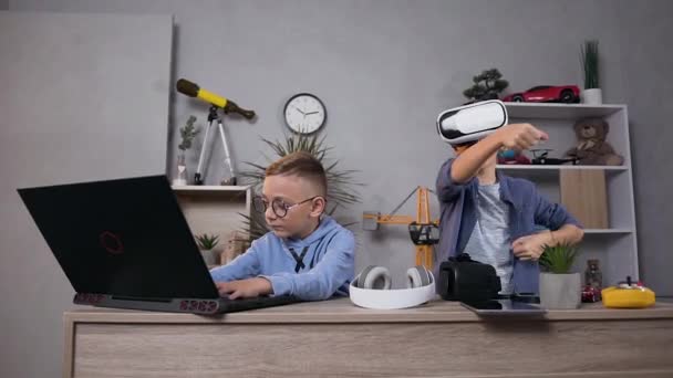 Добре виглядають хлопчики-підлітки, які грають у відеоігри за допомогою комп'ютера та доповнених віртуальних окулярів у дитячій кімнаті — стокове відео