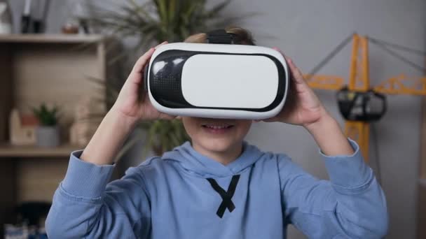 Lächelnder 7-jähriger intelligenter Junge mit Virtual-Reality-Brille beim Spielen in seinem Zimmer — Stockvideo