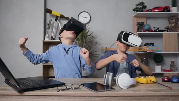 Крупним планом красиві сучасні хлопчики-підлітки, які розважаються разом під час гри, використовуючи окуляри доповненої реальності — стокове відео