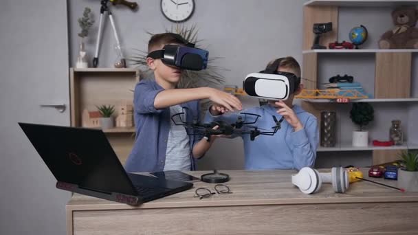 Atractivos chicos adolescentes concentrados estudian la construcción de drones con auriculares de realidad virtual — Vídeos de Stock