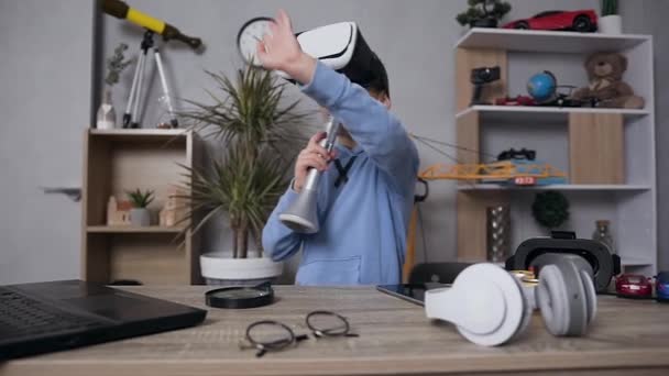 Rolig stilig tonåring pojke med hjälp av virtuell verklighet headset sång i mikrofon som en stjärna sångare hemma — Stockvideo