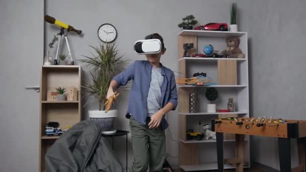 Przystojny nastolatek walczy z mieczem zabawki w specjalnych wirtualnych okularach 3D w jego pokoju zabaw — Wideo stockowe