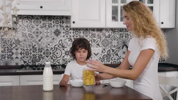 Retrato de una hermosa joven desayunando con su hijo de cinco años en la cocina — Vídeos de Stock