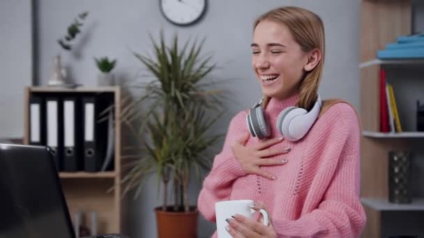 Slow motion of gorgeous cheerful happy girl in modish sweater which revisioning amusing videos on computer and laughing with all her heart — 비디오