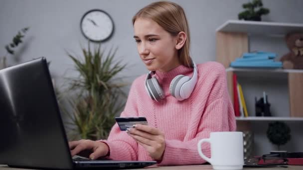 Widok z przodu czarujący zadowolony blondynka długie włosy kobieta w modnych ubrań, które sprawdzają poprawność jej dane karty kredytowej na ekranie komputera — Wideo stockowe