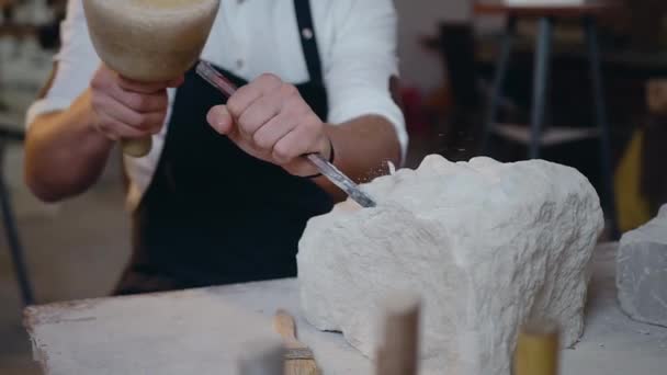 Vooraanzicht van professionele mannelijke handen die de hamer en beitel vasthouden en de vorm van toekomstig beeldhouwwerk afstoten — Stockvideo