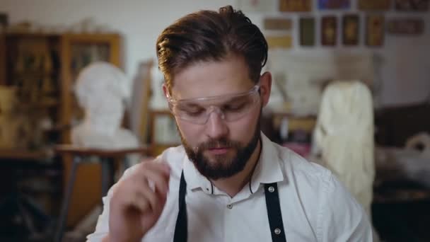 Mouvement lent d'agréable 30-vieux maître masculin créatif qui enlève ses lunettes et regarde la caméra avec un joli sourire — Video