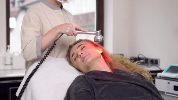 Belle femme blonde adulte avec de longs cheveux bouclés ayant un nettoyage par ultrasons dans un salon de spa — Video