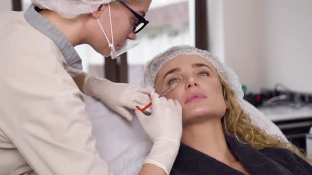 Close up of splendid blond woman which for rejuvenation her face skin entering pricks with required active components in beauty center — Stock Video