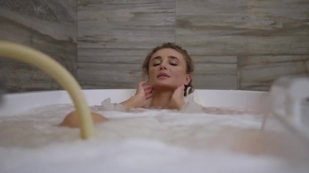 Vonzó elégedett nő élvezi a hidromasszázs eljárás speciális fürdő spa szalonban — Stock videók
