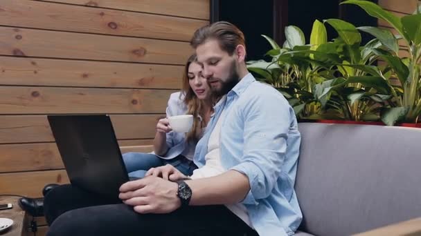 Close-up van aangename tevreden jaren '30 paar man en vrouw die samen zitten in de lobby en met behulp van laptop — Stockvideo