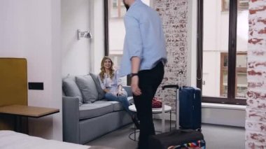 Yakışıklı sakallı genç adam otel odasına giriyor ve kanepeye düşüyor. Orada güzel kız arkadaşı oturuyor ve ona sarılıyor.