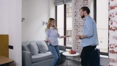 Güzel görünümlü, modern sakallı adam ve güzel sarışın kız arkadaşı otel odalarında dans ediyorlar.