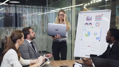 Business concept where attractive blond business lady presenting business strategy using flip chart board for the diverse good-looking confident business people