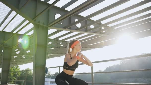 Portrait attrayant de la jeune femme mince sportive qui fait des exercices de squat à l'extérieur — Video