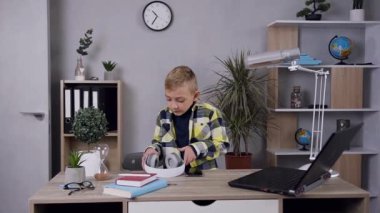 Kulaklık takan ve evde müzik dinlemekten zevk alan çekici bir genci yakından çek.