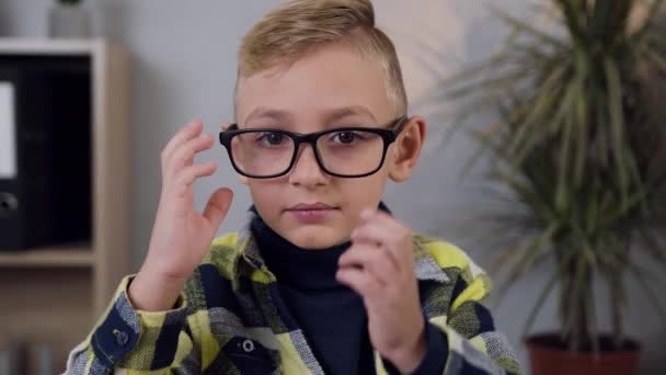 Attractive blond 10-aged boy taking off eyeglasses and showing the sign OK while looking at camera — 비디오