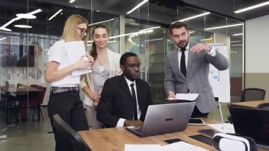 Good-looking satisfied multiethnic group of business people discussing together the further actions about joint business project