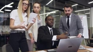 Front view of good-looking professional purposeful young business colleagues which working together under business project