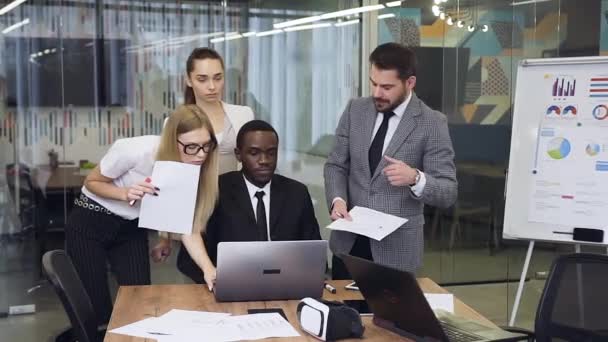 Movimiento lento de gente de negocios de razas mixtas atractivas y laboriosas que discuten un proyecto conjunto en la sala de reuniones — Vídeos de Stock