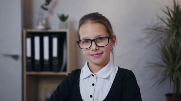 Elölnézetből a meglehetősen lelkes iskolás lány szemüvegben, amely pózol a kamera szép mosollyal — Stock videók