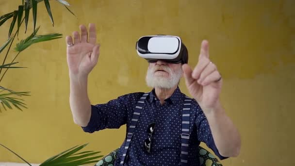 Slow motion of concentrated confident senior gray-bearded man which working on imaginary screen using special 3d glasses — Stockvideo