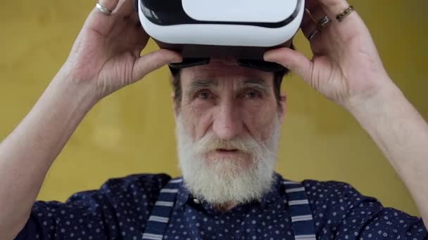 Front view of smiling satisfied attractive bearded man which taking off virtual reality headset and looking at camera — Stok video
