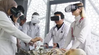 Portrait of high-skille team of mixed race doctors of surgeons using virtual reality reality glasses while studying the skeleton mode