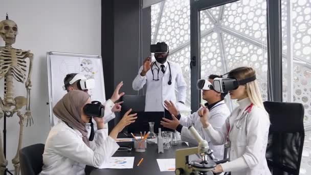 Equipe de médicos multiétnicos altamente qualificados usando tecnologia de realidade virtual para estudar medicina moderna . — Vídeo de Stock