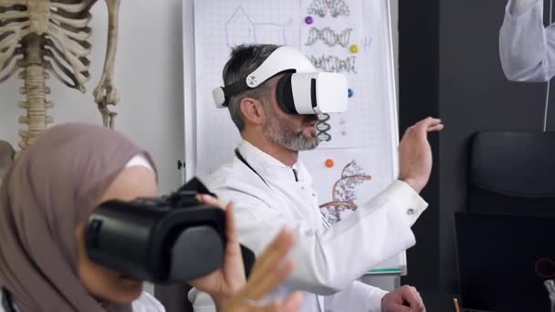 Vue latérale de médecins ou de scientifiques qui apprennent la médecine en simulation avec les lunettes de réalité virtuelle — Video