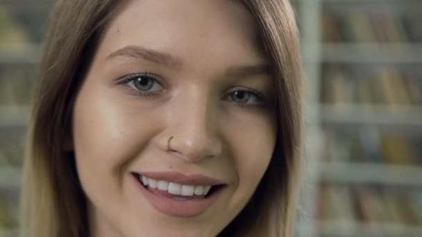 Vue rapprochée de charmante jeune femme moderne souriante avec boucle d'oreille dans le nez qui pose sur la caméra avec expression faciale heureuse — Video