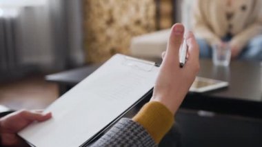 Dizini notlarla tutan ve açıklayıcı hareketler yapan zarif adamların ön görünümü