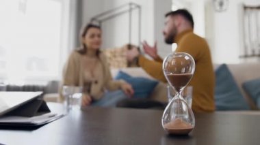 Kum saati, sinirli sakallı kocasıyla tartıştığı sırada rahatsız genç bir kadının, psikolog odasında kanepeden kalktığı zamanı hesaplıyor.