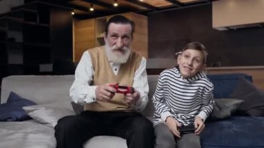 13 yaşındaki neşeli torunuyla oyun oynayan heyecanlı emekli sakallı dedesinin ön görüntüsü.
