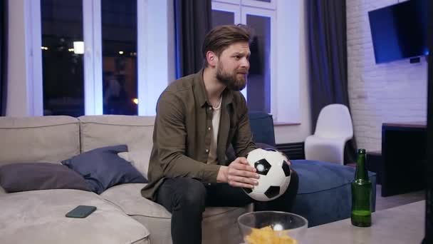 Excited handsome young fierce football fan disappointing from the result of match and tired falling on the sofa — Αρχείο Βίντεο