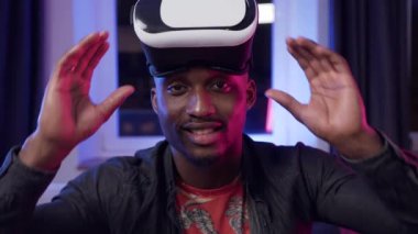 Close up of good-natured happy smiling dark-skinned guy which putting on special 3d glasses and starting to work on imaginary screen