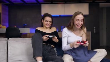 Güzel tasarlanmış apartman dairesinde oyun kağıtlarıyla oynarken birlikte eğlenen genç, pozitif, heyecanlı kadınlar.