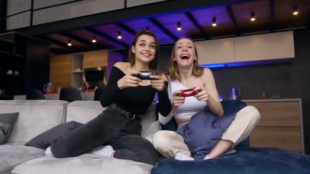 Vista frontale di allegro positivo emotivo 25s ragazze che si divertono insieme durante la riproduzione di videogiochi e dopo aver terminato il gioco celebrare la vittoria — Video Stock