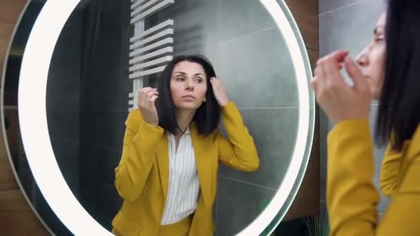 Attraente giovane donna d'affari dai capelli neri che si guarda allo specchio dopo essersi vestita a casa — Video Stock