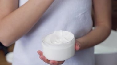 Bilinmeyen bir kadın beyaz havluyla vücuduna basıyor ve omzuna uyguluyor cilt bakımını rahatlatıyor.