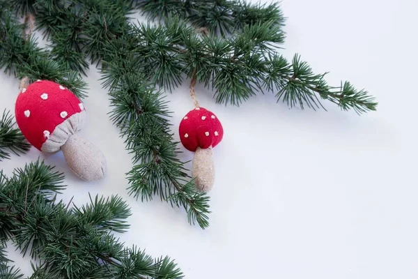 Gros plan branches de cèdre et décoration de Noël champignon sur un fond blanc. Fond de Noël. Concentration sélective. Le lieu du texte . — Photo