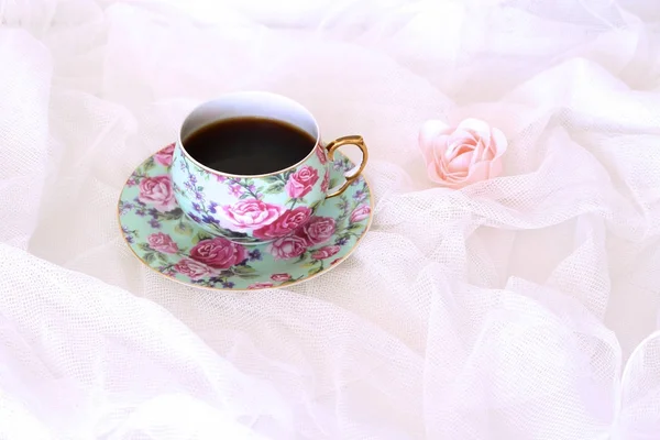 Ochtend hete koffie in een mok en roze bloemetje op witte satijnen achtergrond. Close-up, bovenaanzicht. Seizoensgebonden, 's ochtends koffie, zondag ontspannen en nog steeds leven concept. Vrije plaats voor tekst. — Stockfoto