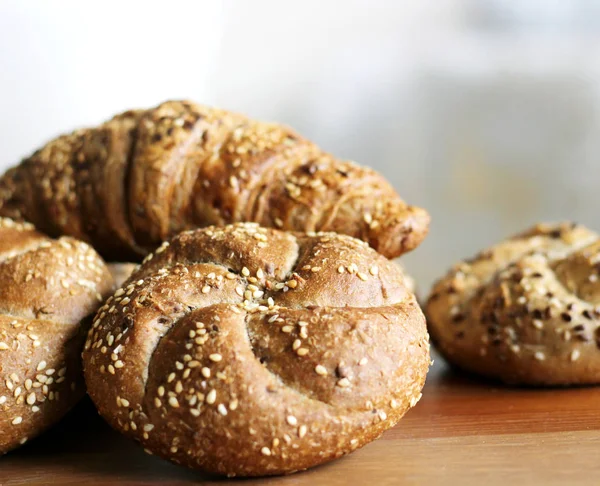 Lezzetli tereyağı kaiser rulo ile keten tohumu ve ayçiçeği tohumu fırından yeni çıkmış. Üstten Görünüm, kopya alanı, seçici odak. Ahşap bir masa üzerinde hamur işleri. Arka plan bulanık. Taze pasta kavramı.