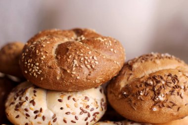Lezzetli tereyağı kaiser rulo ile keten tohumu ve ayçiçeği tohumu fırından yeni çıkmış. Üstten Görünüm, kopya alanı, seçici odak. Ahşap bir masa üzerinde hamur işleri. Arka plan bulanık. Taze pasta kavramı.