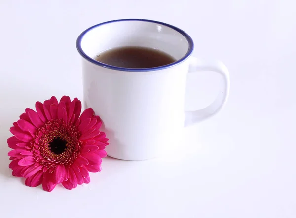 Gerbera-Blüten und eine heiße Tasse Tee auf einem Holztisch. saisonal, Morgentee, Sonntagsentspannung und Stilllebenskonzept. freier Platz für text.food-Konzept. — Stockfoto